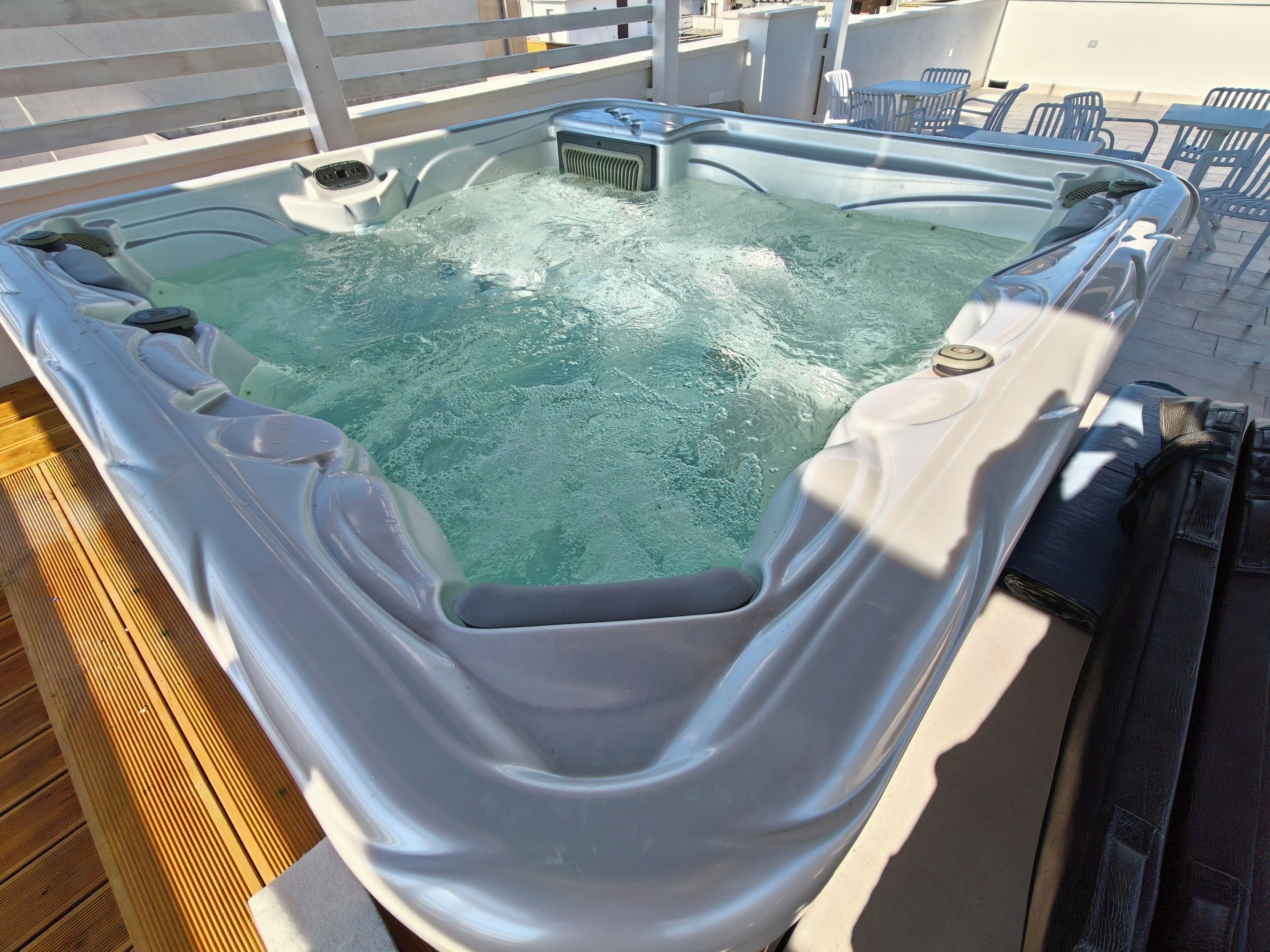 A hot tub with a wooden deck surrounding it.