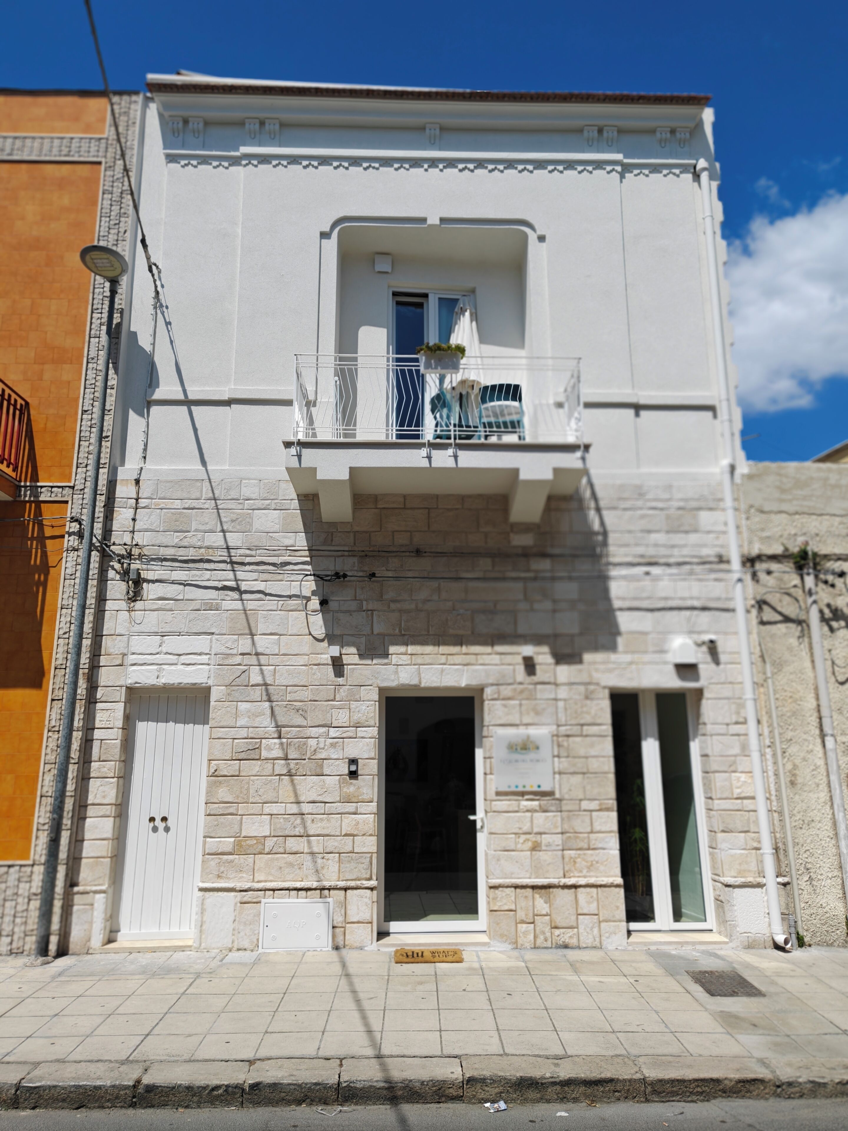 Un edificio con balcón, puerta y ventana.