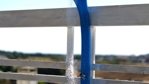 A blue showerhead attached to a white wooden structure with a clear sky in the background. - A brand-new facility in the center of Pulsano (TA), opening in July 2026! (Pulsano)
