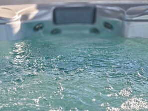A hot tub with a digital control panel and bubbles on the water surface. - A brand-new facility in the center of Pulsano (TA), opening in July 2026! (Pulsano)