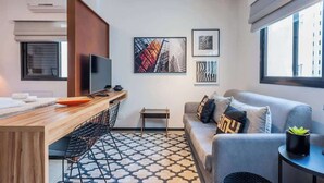 A modern living room with a sofa, a coffee table, a TV, and artwork on the wall. - Advance by Bhomy (São Paulo)