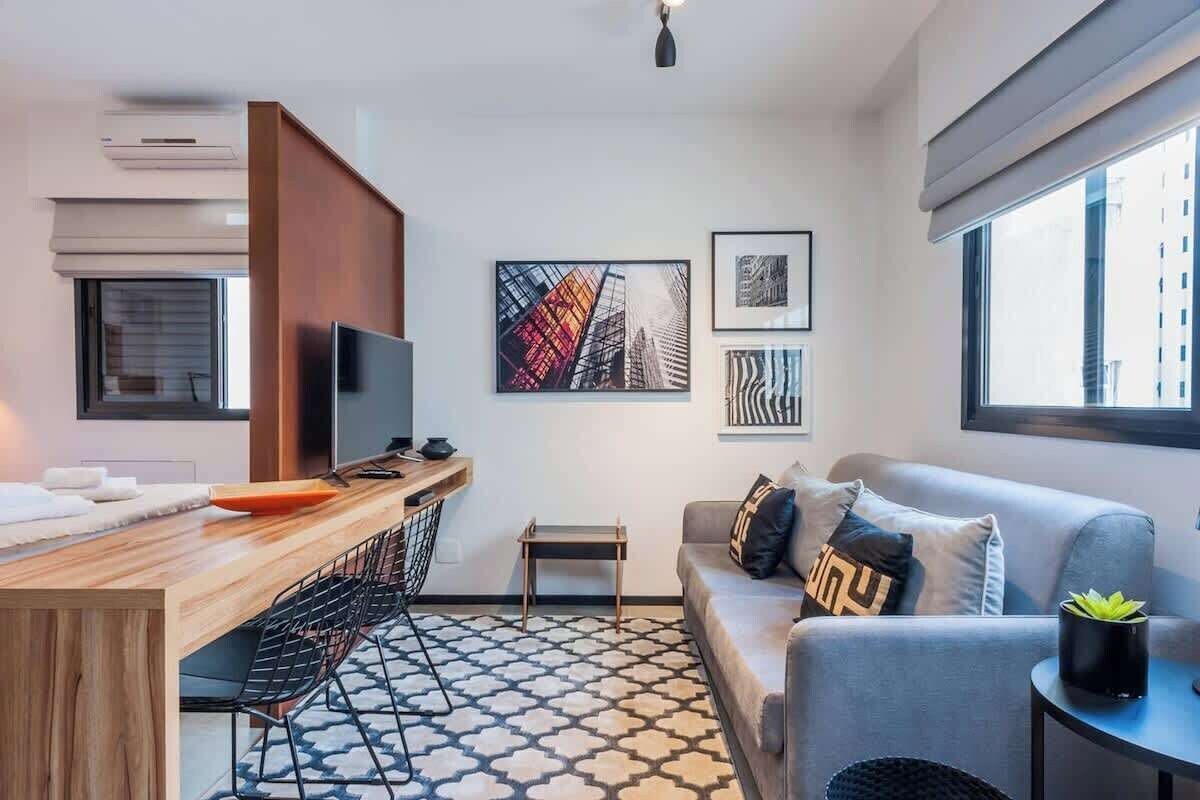 A modern living room with a sofa, a coffee table, a TV, and artwork on the wall.
