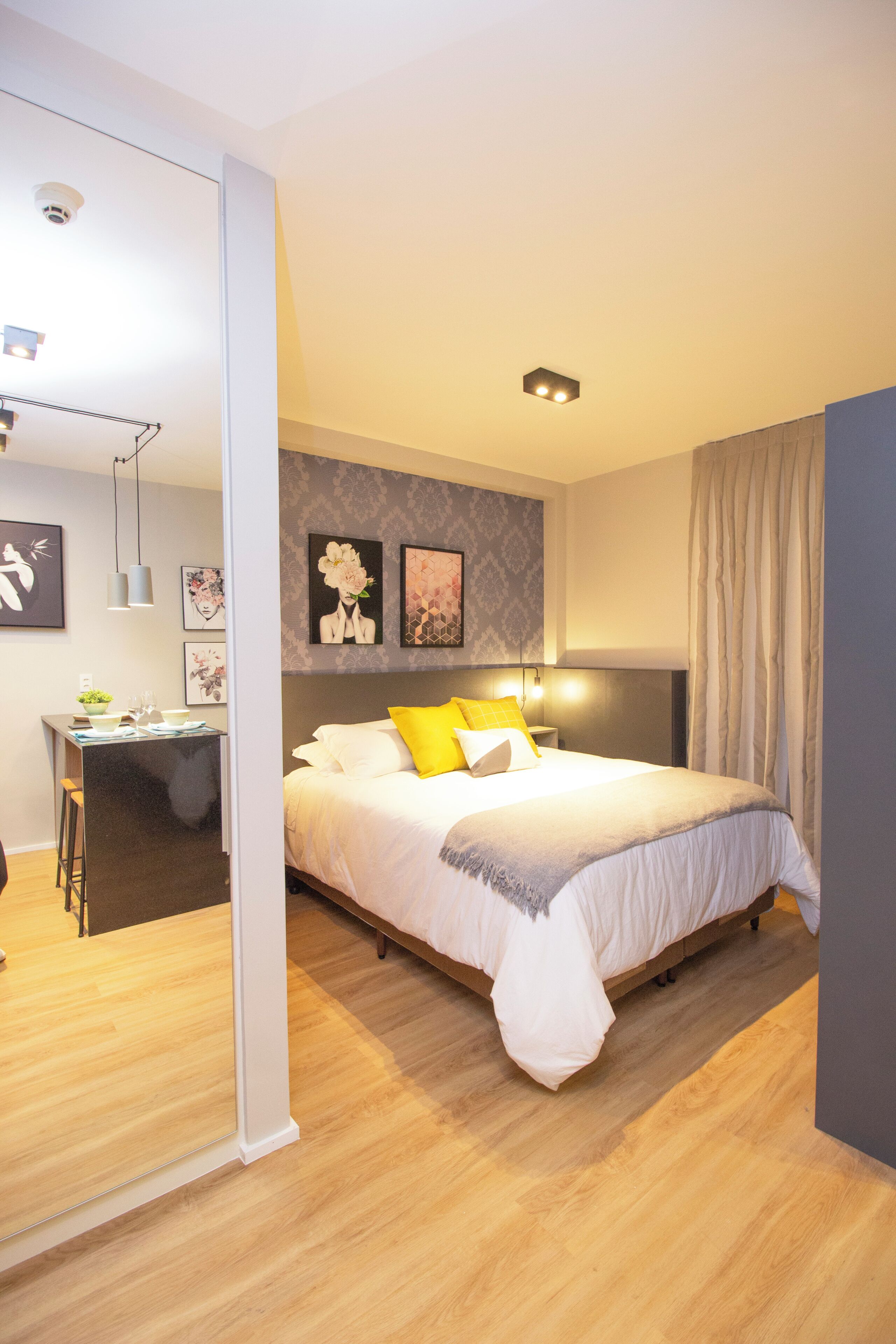 Um quarto moderno com uma cama grande, mesas de cabeceira e um espaço para trabalhar.