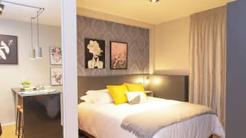 Um quarto moderno com uma cama grande, mesas de cabeceira e um espaço para trabalhar.