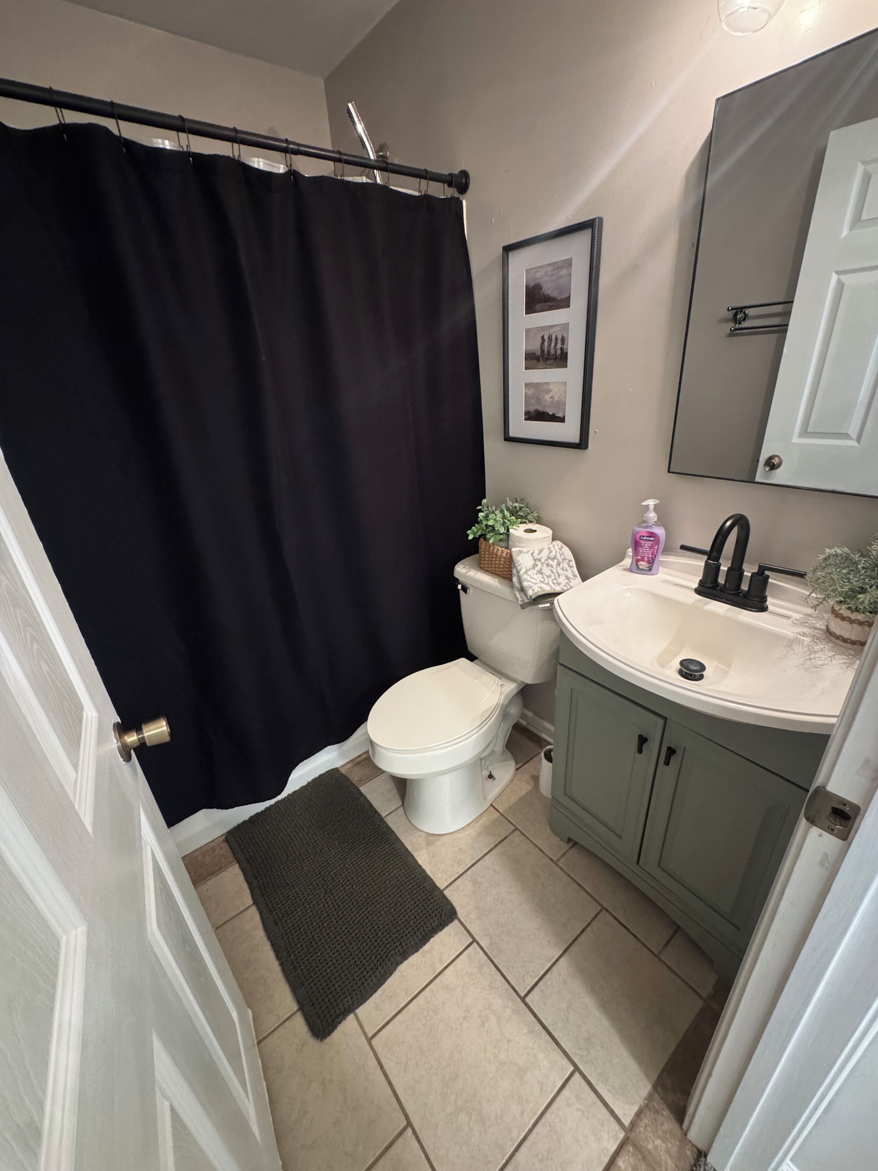 Ein Badezimmer mit Toilette, Waschbecken und Duschvorhang.