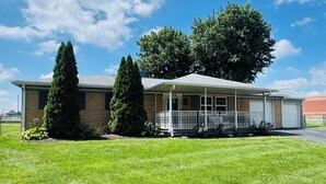 A single-story house with a front porch, a garage, and a well-maintained lawn.