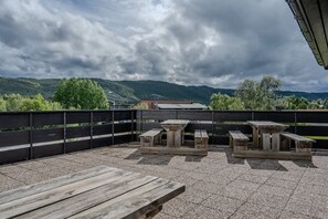 Un espacio al aire libre con mesas de picnic y vistas a montañas.