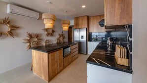 Una cocina moderna con armarios de madera, una isla central e iluminación colgante.