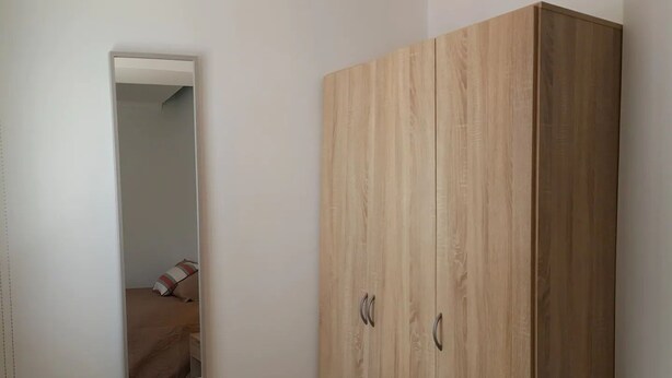 A room with a large wardrobe, a mirror, and a bed. - One-bedroom apartment 150 meters from Praia da Rocha (Portimão)