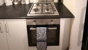 A compact kitchen with a gas stove, oven, and a stainless steel range hood. - Spacious 3BR Doncaster Home Near Racecourse, Shopping & Attractions (Doncaster)