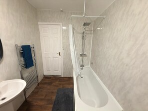 Chuveiro, secador de cabelo, toalhas de banho, papel higiênico