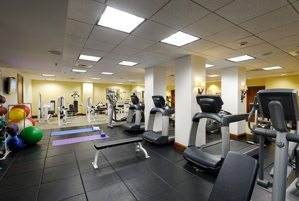 Une salle de sport équipée de tapis de course, de ballons d’exercice et d’appareils de musculation.