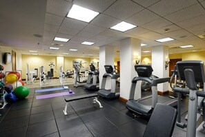 A gym with treadmills, exercise balls, and weight machines.