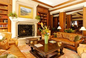 A traditional library with leather sofas, bookshelves, and a fireplace. - Ritz-Carlton Aspen Ski-in Ski-out 3BR+3.5BA Luxury Residence with Full Kitchen (Aspen)