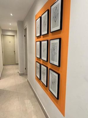 Een gang met lijstwerken aan de muur en een deur met daarop het getal '18' op de achtergrond.