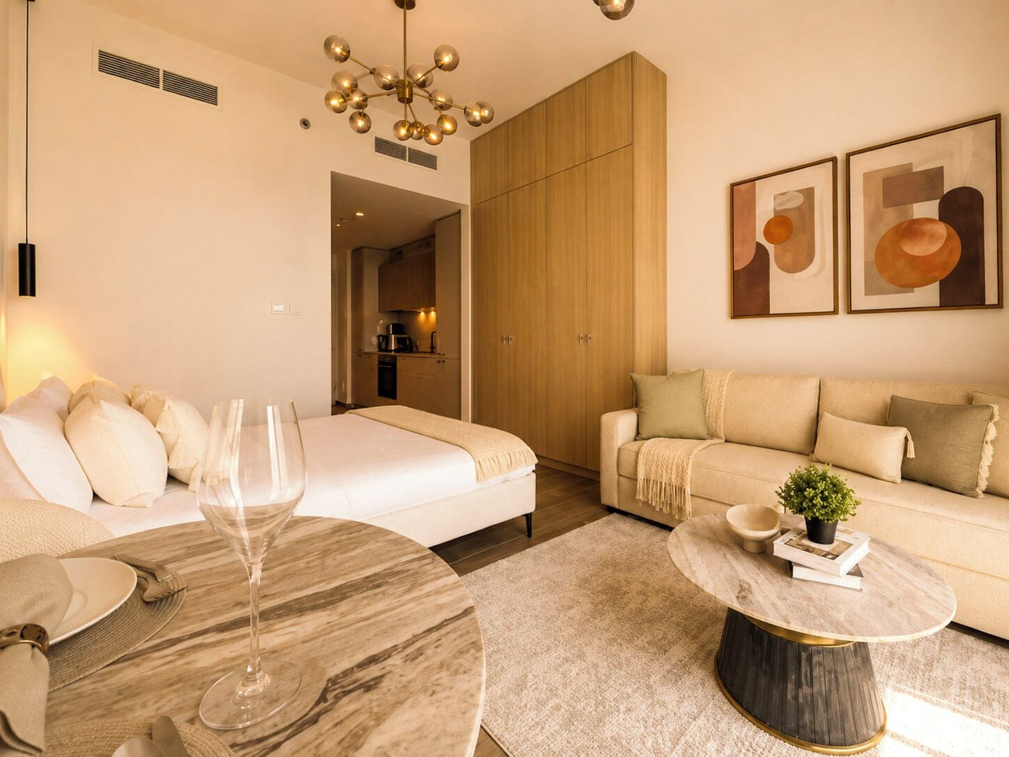 A modern living room with a sofa, a dining table with a glass top, and a kitchen in the background.