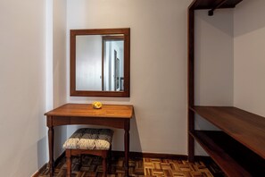Ein Zimmer mit einem Holztisch, einer Bank, einem Spiegel und einem Holzregal.