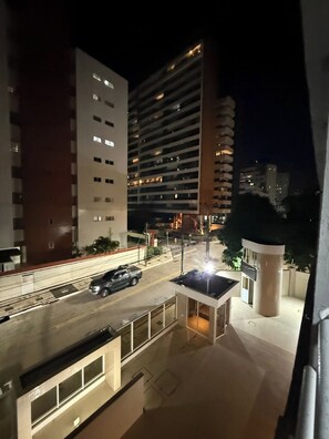 A nighttime view of a multi-story building with a parking area and a small structure with a roof. - 2-bedroom apartment in perfect Fortaleza with refreshing AC (Fortaleza)