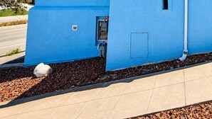 Un bâtiment bleu avec un toit plat, une fenêtre et une porte.