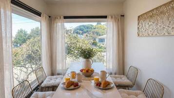 A dining area with a table, chairs, and a view of the outdoors.