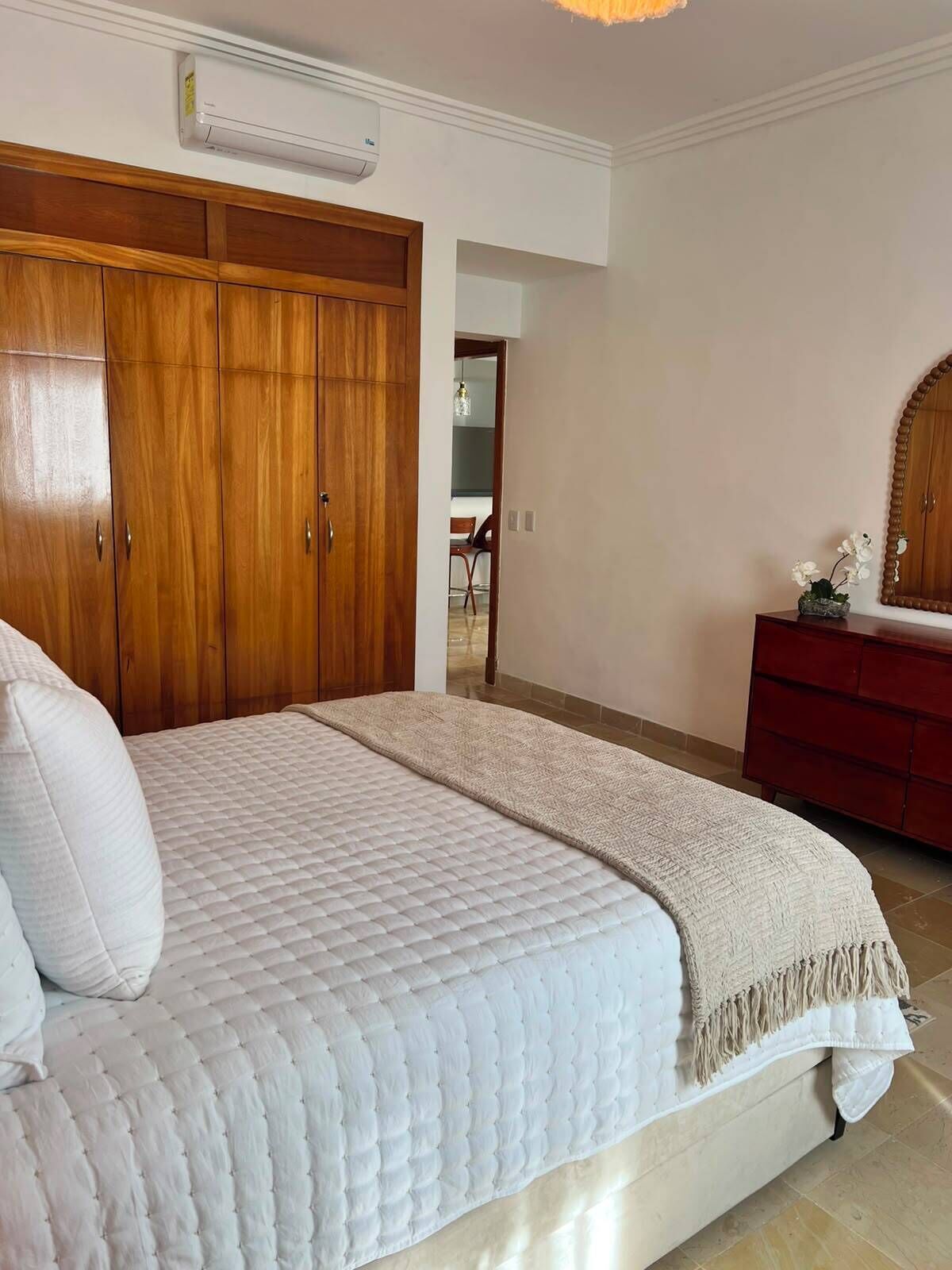 Ein Schlafzimmer mit einem großen Bett, einem Holzschrank und einer roten Kommode.