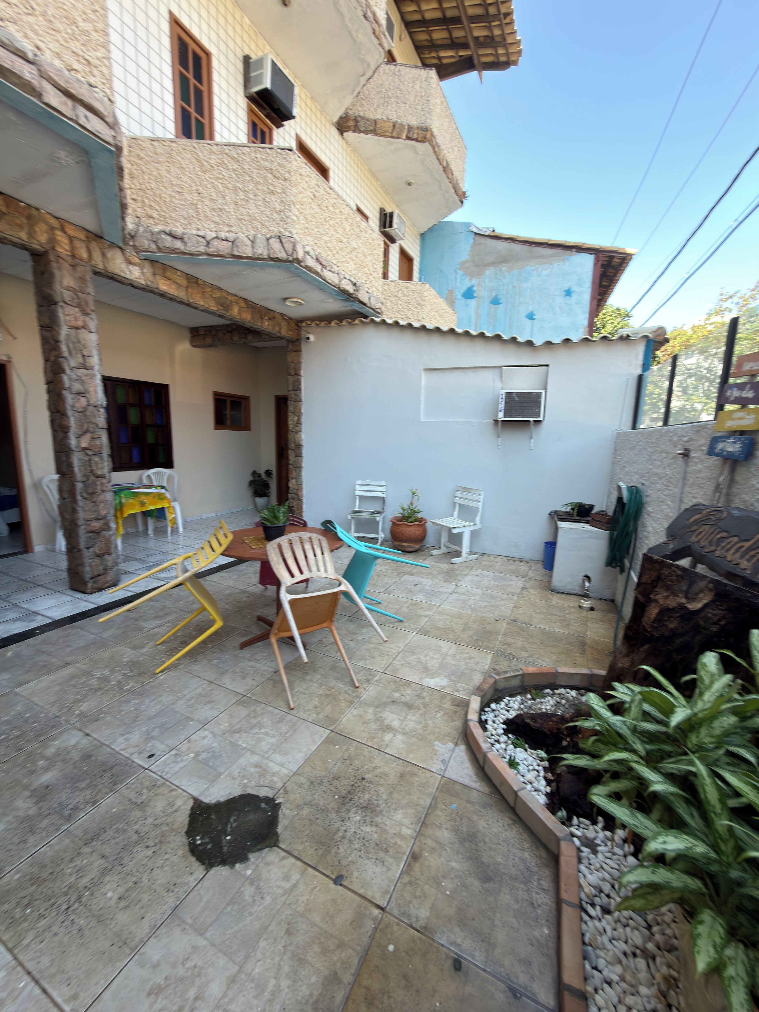 Un'area patio con pavimento piastrellato, mobili da esterno e piante in vaso.
