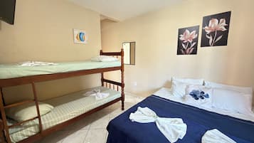 Ein Zimmer mit Etagenbetten, einem Einzelbett, einer blauen Decke und Handtüchern.
