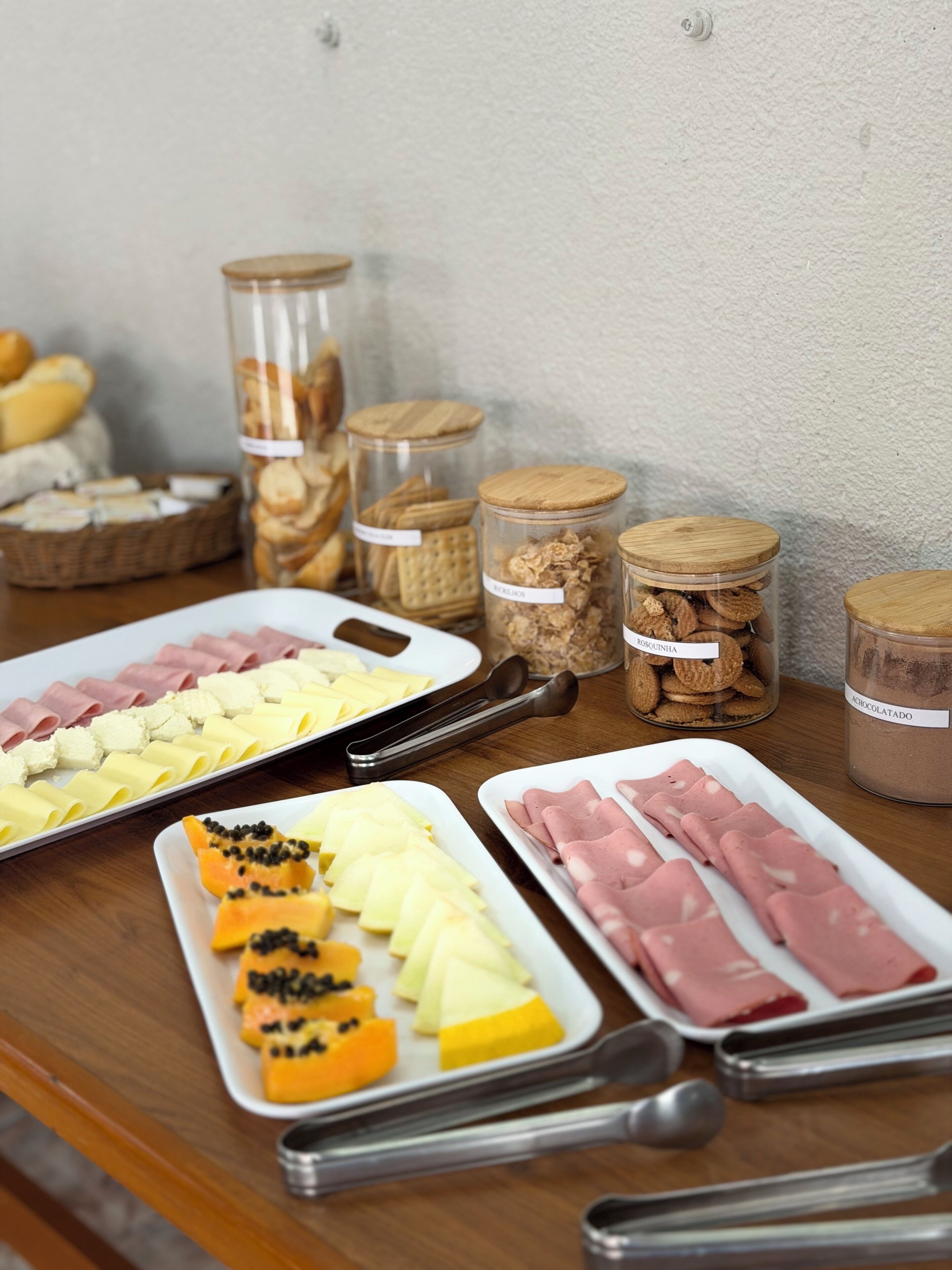 Ett bord med olika sorters mat, inklusive skivad charkuterier, ostar och frukt.