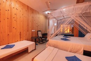 Una habitación con paredes de madera, una cama con mosquitero, una silla y una mesita.