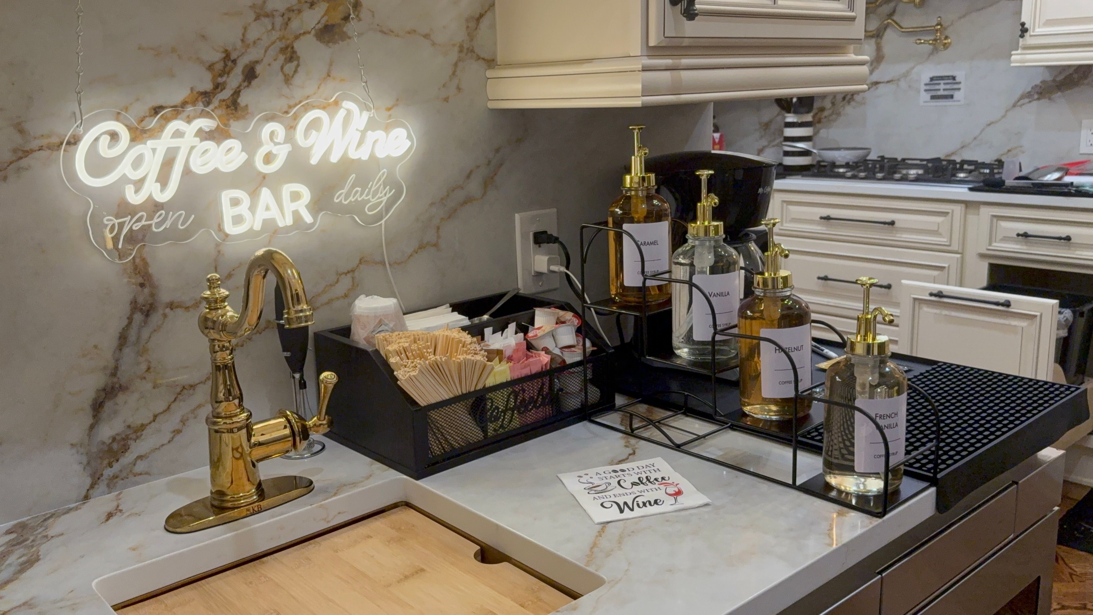 Un bancone cucina con insegna da caffetteria e wine bar, un rubinetto dorato e diversi distributori di caffè.