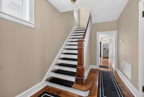 Entryway and staircase with parquet flooring and black runner rugs. - Historic Forest Hill Single Family Near NYC (Newark)