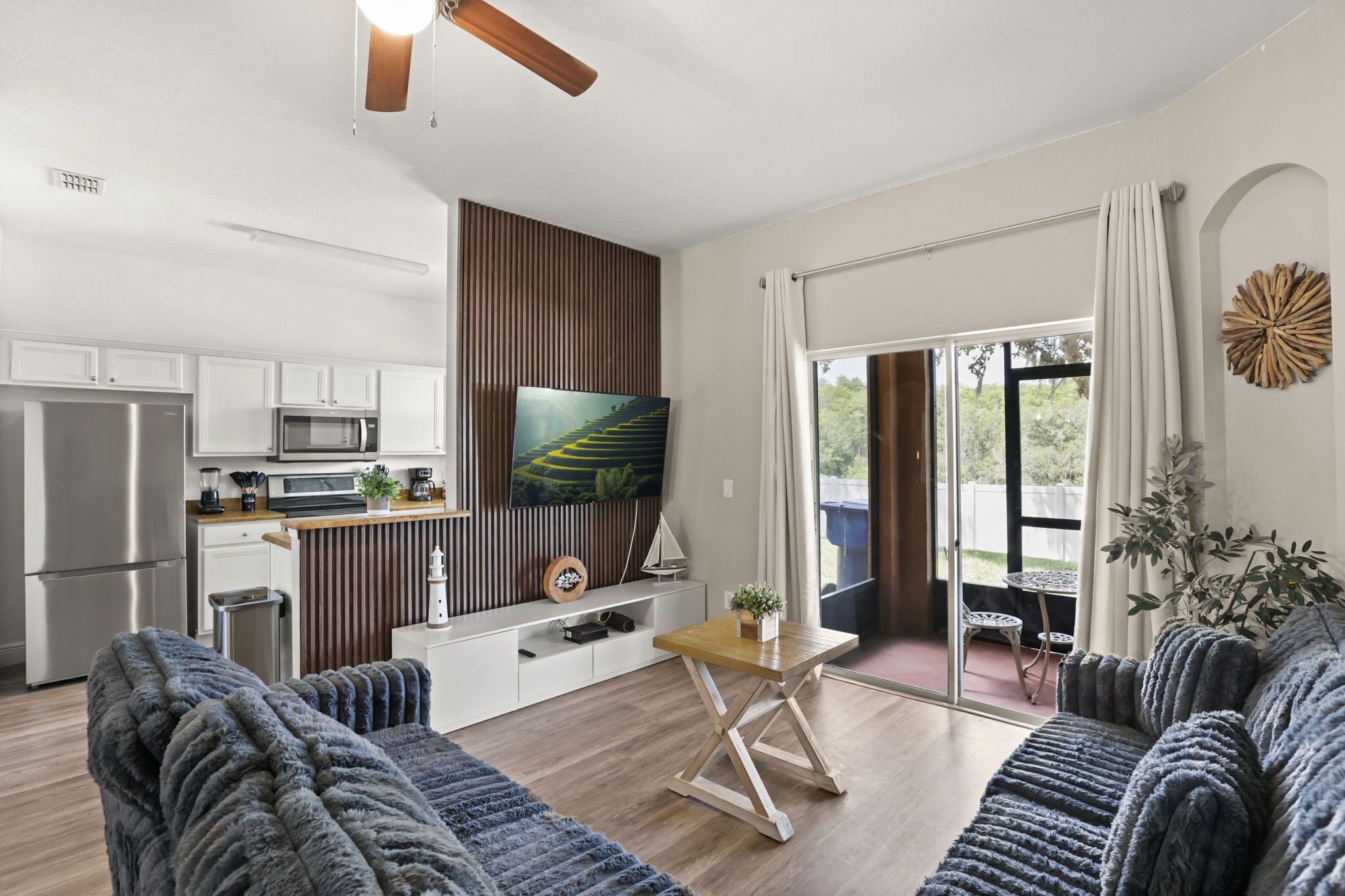 A modern kitchen with white cabinets, a stainless steel refrigerator, and a microwave.