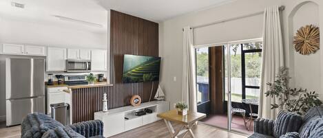 A modern kitchen with white cabinets, a stainless steel refrigerator, and a microwave.
