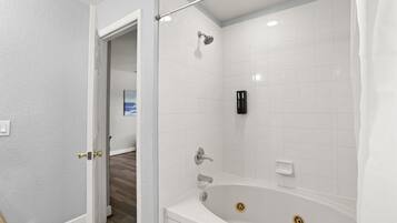 Un baño con bañera, ducha e inodoro.