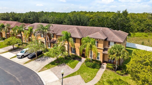 A residential area with multiple two-story houses, paved walkways, and a parking area. - 4 BD/ 3 BA/ Regal Palms (3214 CA) (Davenport)