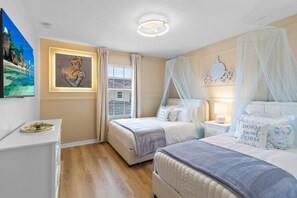 Een slaapkamer met twee bedden, nachtkastjes, een raam met gordijnen, een schilderij en een plafondlamp.