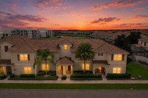 A residential building with a symmetrical facade, multiple windows, and a well-maintained lawn. - 4 BD/ 3 BA/ Storey Lake (4796 CT) (Kissimmee)