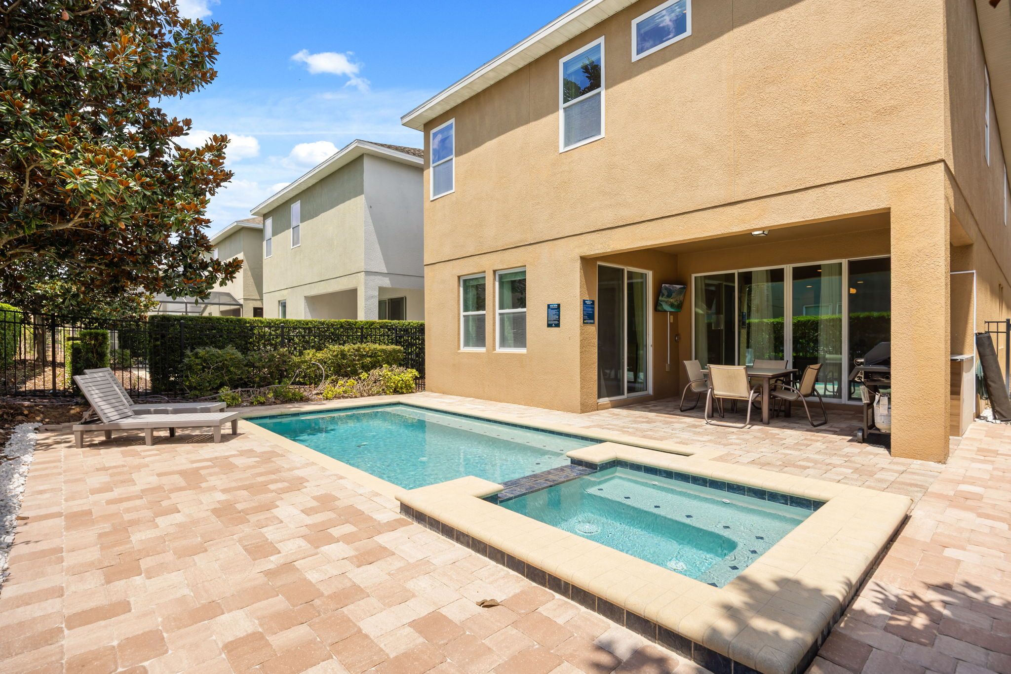 A residential building with a swimming pool, outdoor seating, and a landscaped garden.