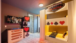 Habitación con cama, cómoda y pared con un letrero de Las Vegas.