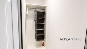 A narrow hallway with a white closet containing shelves and a hanging rack. - ANYA APARTAMENTS (Bayahibe)
