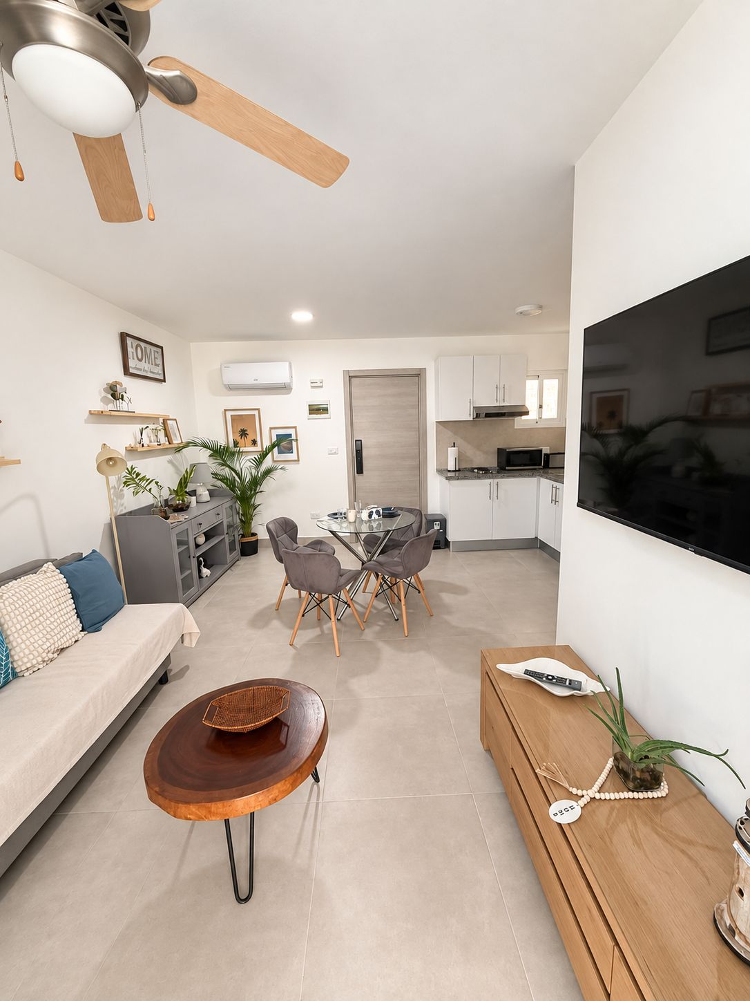Uma sala de estar moderna com sofá, mesa de centro e área de jantar.