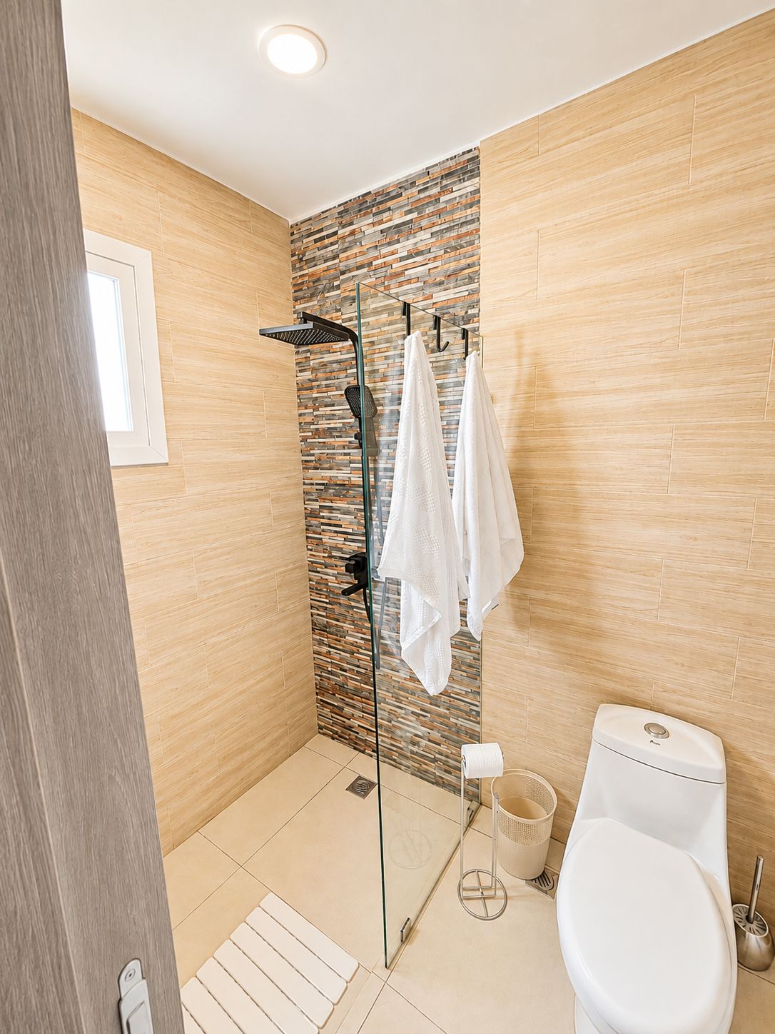 Une salle de bain moderne avec une douche à parois de verre, des toilettes et un lavabo.