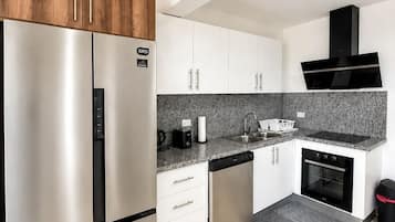 Departamento Confort, balcón, vista a la ciudad | Cocina privada | Refrigerador con congelador, microondas y parrilla de estufa