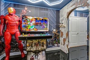 A room with a large Iron Man statue, a gaming console with a Batman game, and a wall with a mural. - Immersive Experience 9 BD/ 5  BA/ Champions Gate (1513 MC) (Davenport)