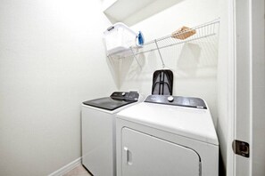 A laundry area with two washing machines and a drying rack. - 7 BD / 5.5 BA / Windsor Cay 1091 OP (Clermont)