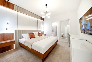 A modern bedroom with a large bed, built-in wardrobe, and a large mirror. - 7 BD / 5.5 BA / Windsor Cay 1091 OP (Clermont)