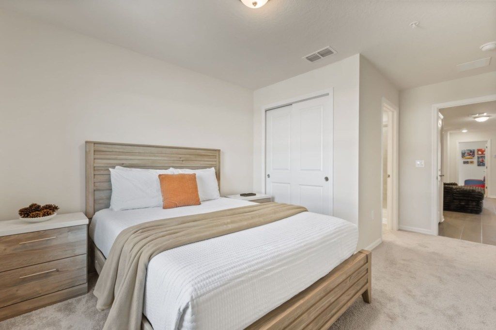 A bedroom with a bed, bedside table, and a door.