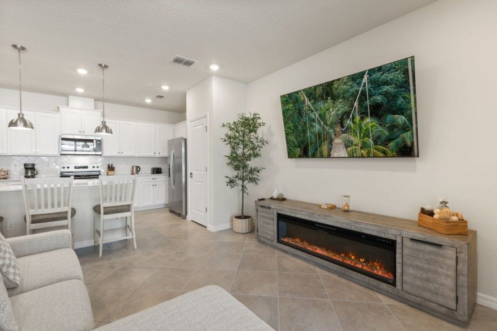 A modern kitchen with white cabinets, a central island, and pendant lighting.