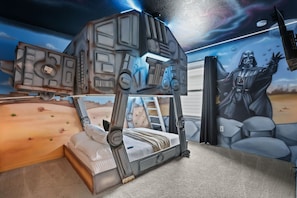 Een kinderkamer met een Star Wars-bed en wanddecoratie.