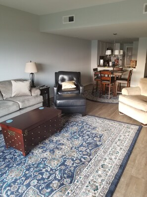 A living room with a sofa, armchair, coffee table, and a patterned rug. - Beautiful 2-bedroom condo with AC in Hilton Head Island (Hilton Head Island)